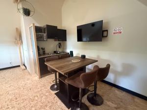 a kitchen with a wooden table and chairs in a room at Le Studio d'Instant Nature in Alexain