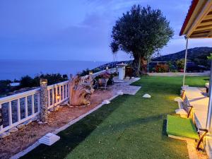 a yard with a fence and a view of the ocean at Off Grid Romance in Samos in Ireon