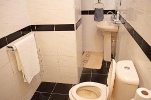 a small bathroom with a toilet and a sink at House Stark in Kilifi