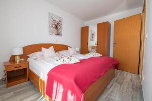 a bedroom with a bed with a red blanket on it at Apartments Anita in Pula +73 photos