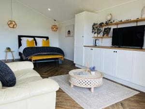 a living room with a white couch and a bed at Coco's Bungalow in Mudgee