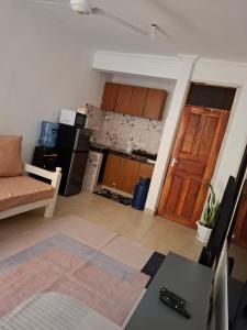 a living room with a kitchen and a door at House Stark in Kilifi
