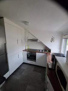a small kitchen with white cabinets and a sink at Ferienwohung Else Sankt Wendel in Sankt Wendel