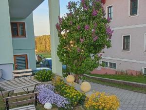 a bench and a tree in a garden with flowers at Wohlfühlwohnung in Rappottenstein +15 photos