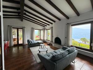 a living room with couches and large windows at Mediterranes Lebensgefühl Tessin in Gerra