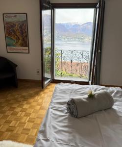 a bed in a room with a large window at Mediterranes Lebensgefühl Tessin in Gerra