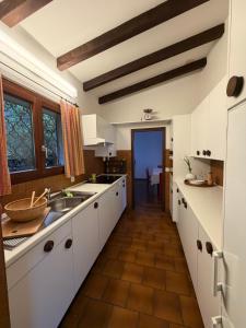 a kitchen with white cabinets and a wooden floor at Mediterranes Lebensgefühl Tessin in Gerra +6 photos