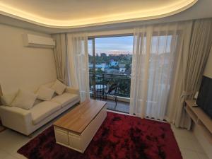 a living room with a couch and a large window at 2BR Fantasea condo kamala in Kamala Beach