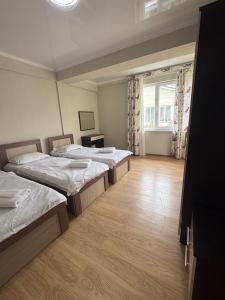 a room with three beds and a window at Танхаус Коттедж in Bosteri