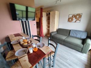 a living room with a table and a couch at Marla 52 in Le Dévoluy