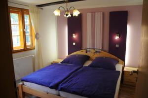 sypialnia z łóżkiem z niebieską pościelą i żyrandolem w obiekcie Ferienhaus am Oeringer Tor w mieście Quedlinburg