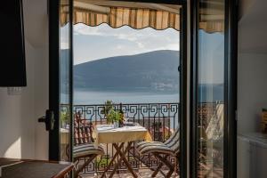 a balcony with a table and chairs and a view of the water at Guesthouse Villa Stari Grad in Herceg-Novi