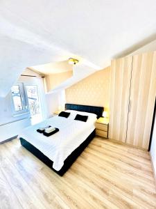 a bedroom with a large white bed and wooden floors at Maja - Apartment 1 in Funtana