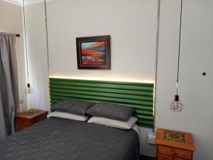 a bedroom with a bed with a green headboard at LISANÉ ACCOMMODATION in Middelburg