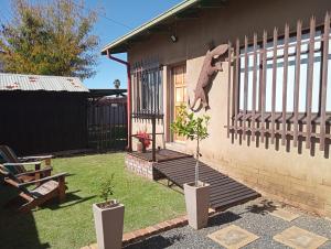 a house with a fence and a plant in a yard at LISANÉ ACCOMMODATION in Middelburg