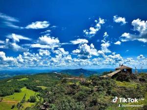 a building on top of a hill with a blue sky at Pousada Nascer da Lua in São Thomé das Letras