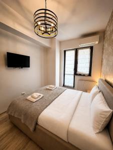 a bedroom with a large white bed and a chandelier at Studio Luxury Center in Iaşi