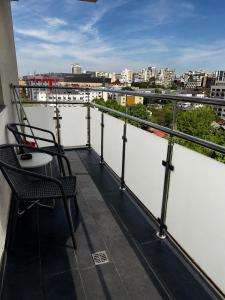 a balcony with two chairs and a view of a city at Studio Luxury Center in Iaşi