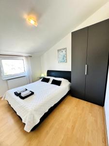 a bedroom with a large bed with a black cabinet at Maja Apartment 2 in Funtana