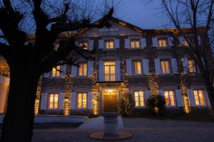 ein großes Gebäude mit nachts beleuchteten Fenstern in der Unterkunft Hotel 2M, The Originals Relais in Saint-Rambert-sur-Loire