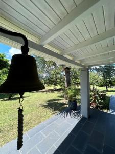 a bell hanging under a white pergola at Villa d'architecte avec piscine in Saint-François
