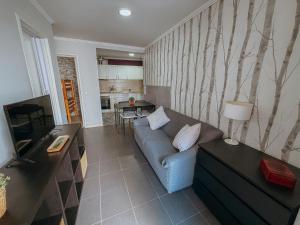 a living room with a couch and a kitchen at Aliciamar 29 by Casas de Setúbal in Setúbal