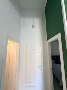 a bedroom with green walls and a white closet at Paloma in Santa Flavia