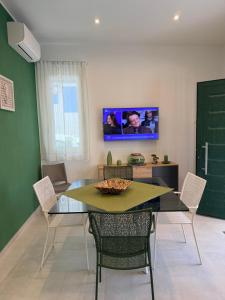 a dining room with a table and chairs and a tv at Paloma in Santa Flavia