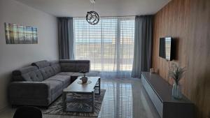 a living room with a couch and a table at Apartman Bartimej 3 in Bobrów