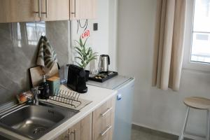 a kitchen with a sink and a refrigerator at Scalo del Mare Apartment in Keramoti +16 photos