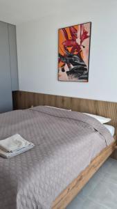 a bed in a bedroom with a picture on the wall at Apartman Bartimej 3 in Bobrów