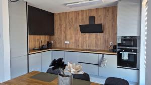 a kitchen with white cabinets and a table with chairs at Apartman Bartimej 3 in Bobrów
