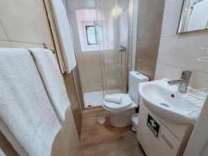 a bathroom with a toilet and a sink and a shower at Aliciamar 29 by Casas de Setúbal in Setúbal +27 photos