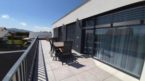 a patio with a table and chairs on a balcony at Apartman Bartimej 3 in Bobrów