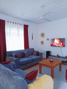 a living room with a blue couch and a table at Devkim Stays-Cozy Comfort Near The Beach in Ukunda
