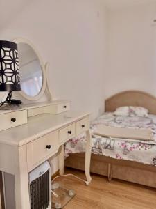 a bedroom with a bed and a dressing table with a mirror at Apartment Guberinic in Tivat