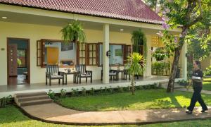 a man walking in front of a house at Habana Angkor Resort in Siem Reap
