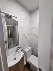a white bathroom with a toilet and a sink at Zatrzymaj Się in Stronie Śląskie +16 photos
