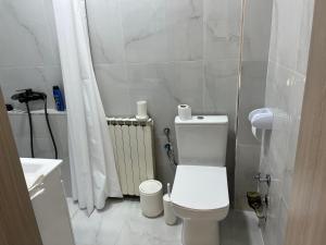 a white bathroom with a toilet and a sink at Center City Stay 2 in Skopje