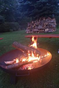 a large grill with fire in a yard at Zatrzymaj Się in Stronie Śląskie