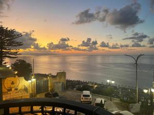 a sunset over the ocean with cars parked in a parking lot at Casa Cucchiara in Bagnara Calabra