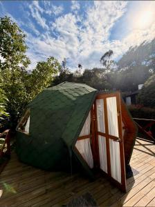 a green dome tent sitting on a deck at Glamping&BBQ San José - Susa Cundinamarca in Susa