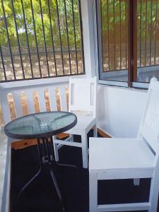 a table and chairs in a room with windows at Devkim Stays-Cozy Comfort Near The Beach in Ukunda +4 photos