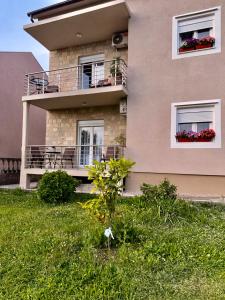 a building with a balcony and flowers in windows at Apartment Guberinic in Tivat