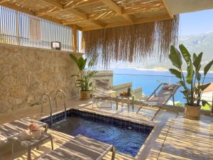 a swimming pool with two chairs and a table at Adasya Hotel in Kaş