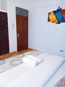 a bed with two towels on it in a room at Devkim Stays-Cozy Comfort Near The Beach in Ukunda