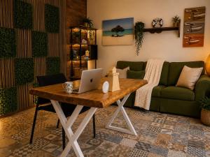 a living room with a table with a laptop on it at Villa Fina Aruba in Palm-Eagle Beach +8 photos
