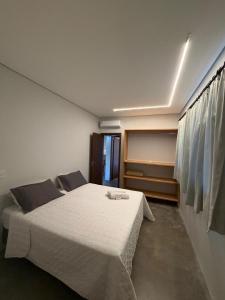 a bedroom with a large white bed in a room at Pitaya Apart Hotel in Garopaba