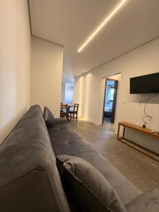 a living room with a couch and a flat screen tv at Pitaya Apart Hotel in Garopaba