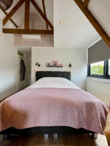 a bedroom with a large bed with a red bedspread at Room at the Beach Egmond in Egmond aan Zee